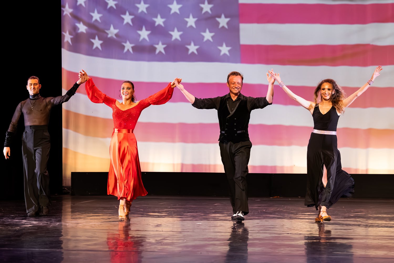 Four Arthur Murray professionals taking a bow at the close of the showcase on the Lewis Auditorium stage.