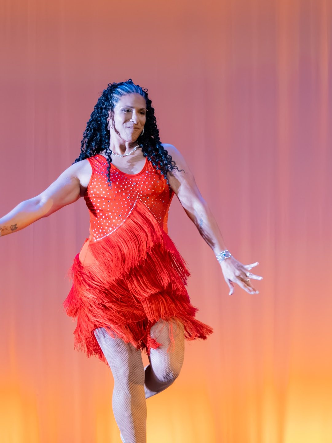 A local celebrity in a red fringe dress mid-routine on the Lewis Auditorium stage.